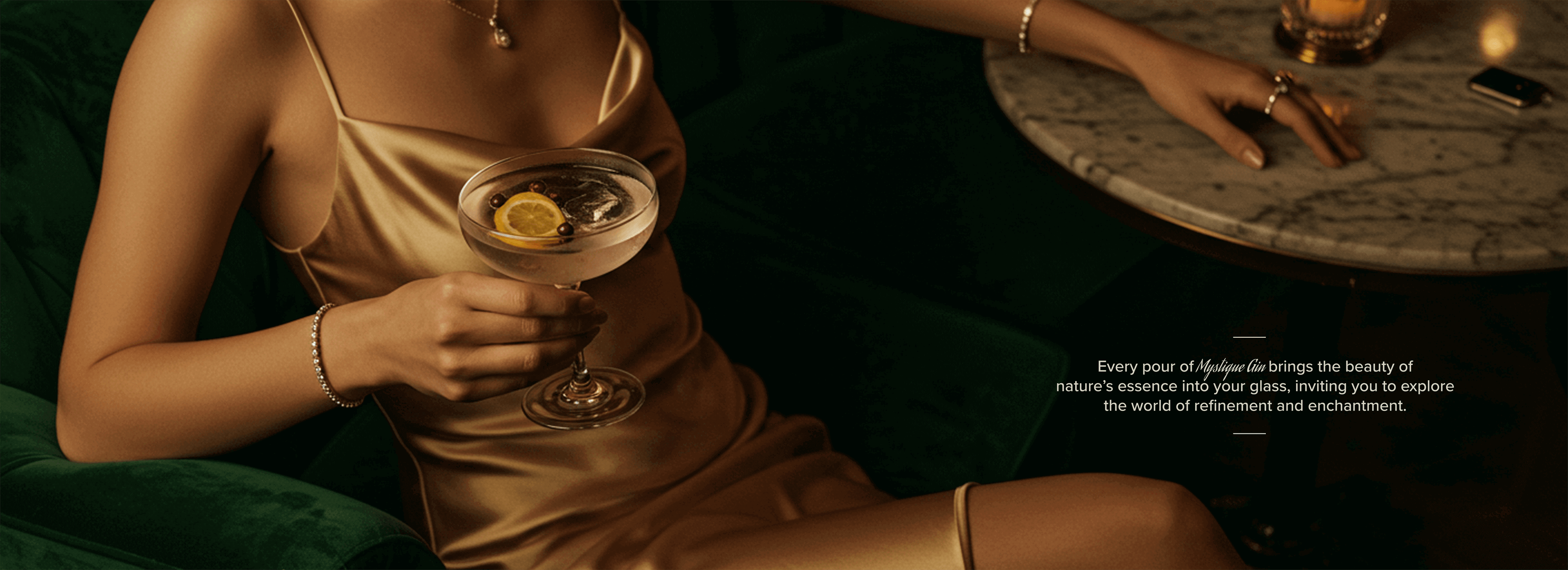 Close-up of a woman's hand with luxury jewelry holding Mystique London Dry Gin cocktail, wearing a gold silk dress in Singapore